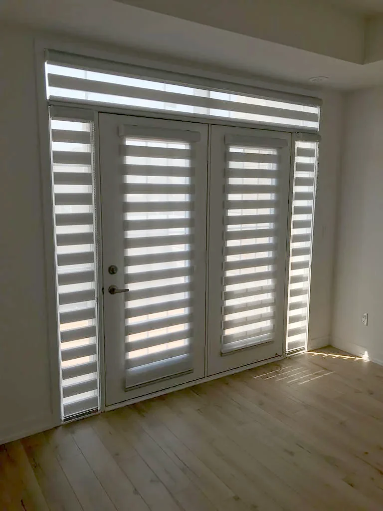 Patio doors with a zebra shade on each door and one across the transom